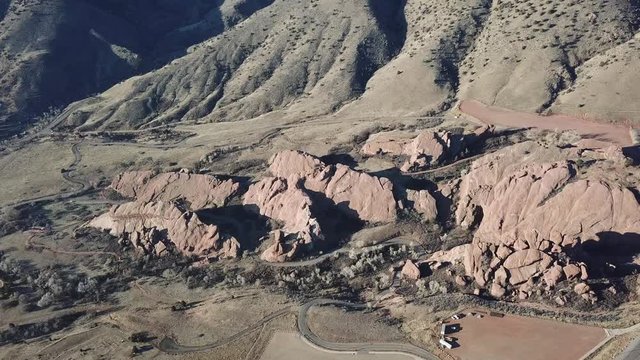 AERIAL: high push over and tilit away from the giant boulders located at the Red Rocks Park in Colorado.