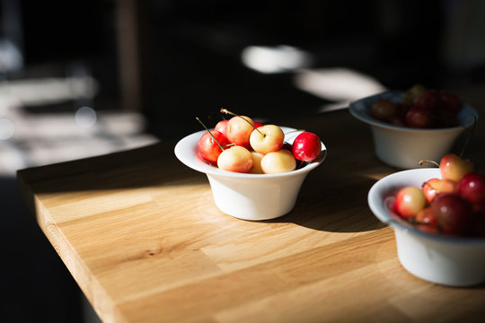 Bowl Of Fresh Cherries On Wooden Table