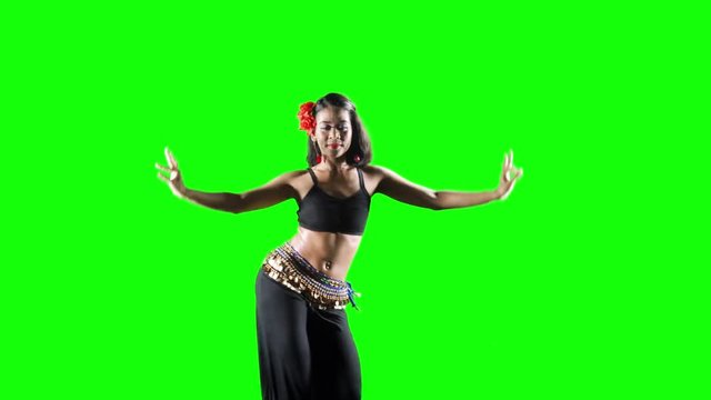 Beautiful young woman exercising zumba dance in the studio. Shot in 4k resolution with green screen background