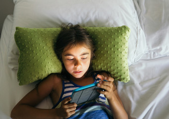 Children playing Tablet on bed at home