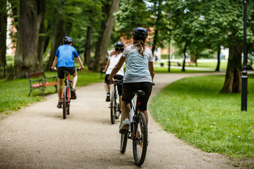 Healthy lifestyle - people riding bicycles in city park
