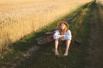 Girl in wheat field with bicycle