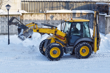 yellow tractor clears snow