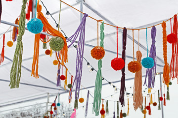 Garland of colored pompons and tassels hanging at the festival.