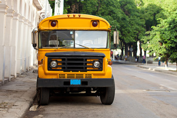 Old yellow american schoolbus in a street of Havana in Cuba parking