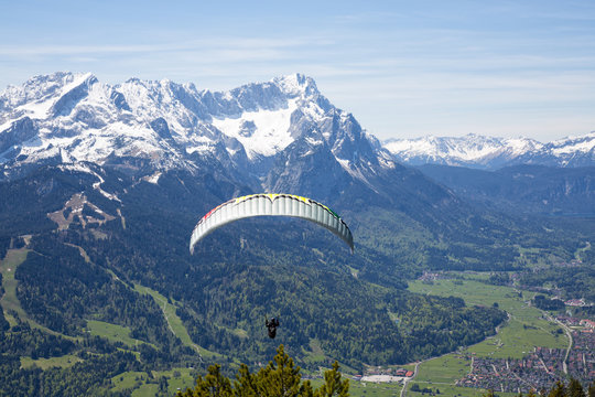 Paraglider setting off from the Wank mountain for a flight above the valley of Garmisch-Partenkirchen, Germany. 