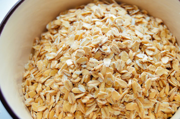 Dry oatmeal in a bowl. Top view. Close-up. Healthy food for vegan breakfast