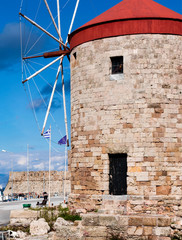 Obraz na płótnie Canvas rhodes,greece old windmills in the port by the sea of aegean