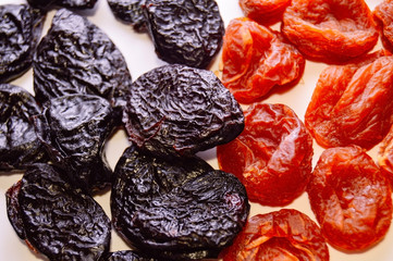 Mix of dried apricots and dried plum - prunes on a white background. Healthy breakfast. Proper nutrition. Top view. Close up