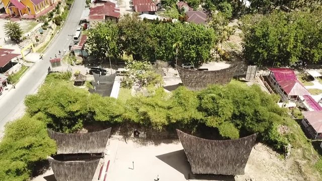 Drone view of traditional Batak houses with thatched roof on Samosir island, Lake Toba, Sumatra, Indonesia.