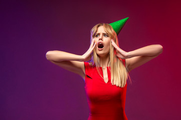 Portrait of a young blonde woman screaming happy, surprised by an offer or a promotion. Holiday, celebration, Christmas sale concept