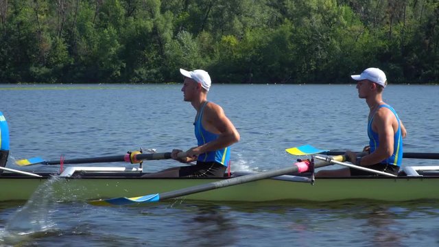 Rowing team summer training. 8 athletes rowers in a boat in the river Dnipro. City area in Kiev, Ukraine