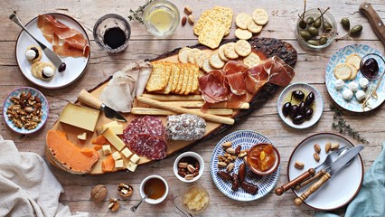 Appetizers table with various of cheese, curred meat, sausage, olives and nuts Festive family or...