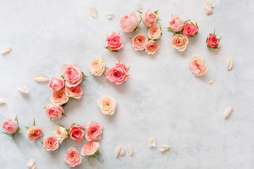 Roses On Textured Background. Various pink roses buds and petals  scattered on rustic background, overhead view, copy space - obrazy, fototapety, plakaty