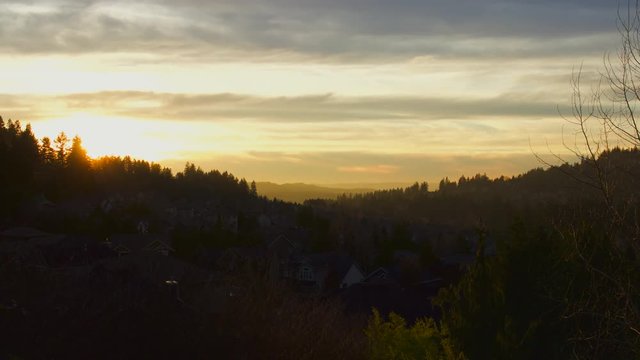 UHD 4K time lapse movie of fiery sunset and colorful clouds over residential suburb homes in Happy Valley Oregon from dusk into evening hour 3840x2160 Ultra High Definition