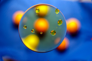 oil circles on water on blue background with orange spots
