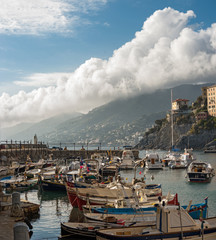 Fototapeta na wymiar Picturesque sky clouds with port of Camogli
