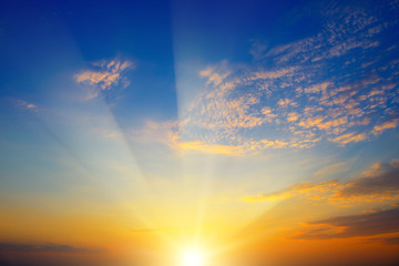 Scenic sunset with sun rays against bright blue sky