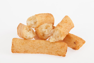 tasty fried yucca sticks on white background