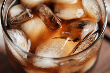 Glass of tasty refreshing cola with ice cubes, closeup