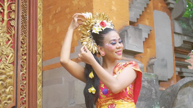 Beautiful balinese woman preparing her hair and accessories before dancing in the temple. Shot in 4k resolution