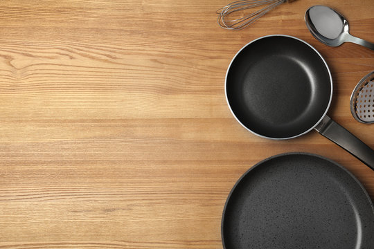Flat lay composition with clean cookware and space for text on wooden background
