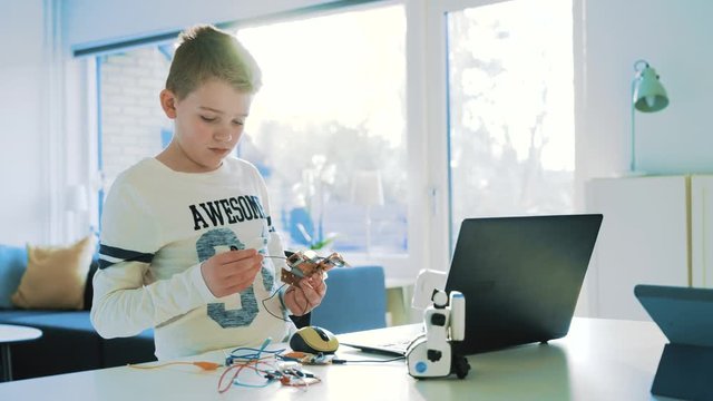 Kid plays with circuit board and tries to design an eletronic device