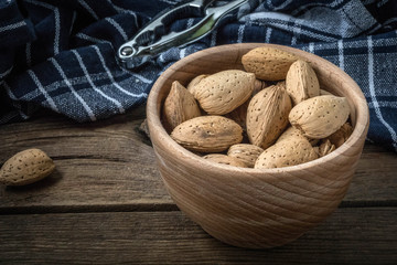 Almonds in-shell in wooden bowl.