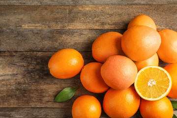 Heap of fresh oranges on wooden table, top view with space for text