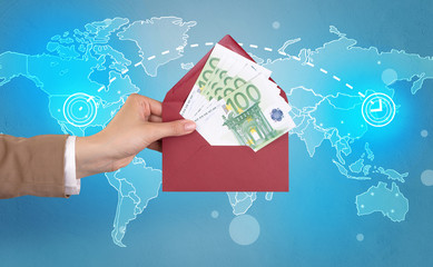 Female hand holding coloured and white envelope with blue map on the background
