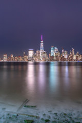 Obraz premium View on Financial district at night from Hudson river beach with long exposure