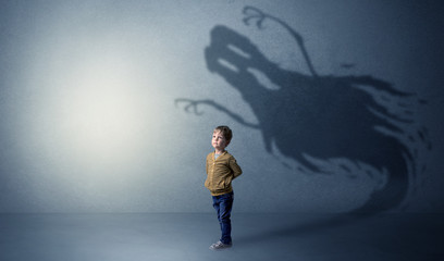 Scary ghost shadow in a dark empty room with a cute blond child
