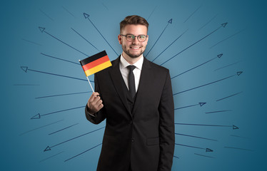 Smiling young man standing with flag and multidirectional arrows around
