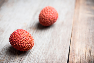 Red ripe lychees on the rustic background. Selective focus. Shallow depth of field.