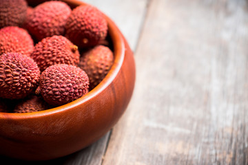 Red ripe lychees on the rustic background. Selective focus. Shallow depth of field.