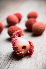 Red ripe lychees on the rustic background. Selective focus. Shallow depth of field.