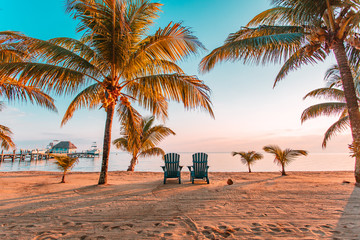 Two empty chairs at a beach sunset