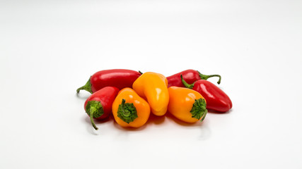 a group of red and orange mini sweet peppers isolated on white