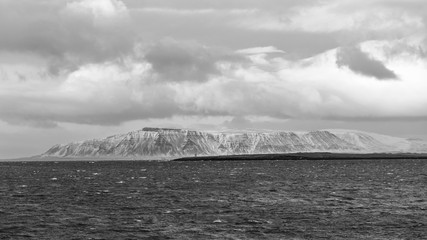 View from Reykjavik, the capital of Iceland. Black and white picture. In the foreground, the ocean...