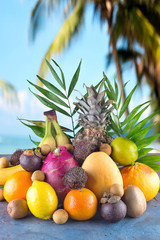 Assorted tropical fruits on the beach orange , pineapple, lime, mango, dragon fruit, orange, banan, rambutan and lichi Group of exotic tropical fruits. Vegetarian healthy concept