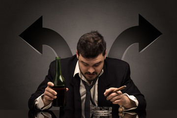Drunk disappointed man sitting at table with arrows around
