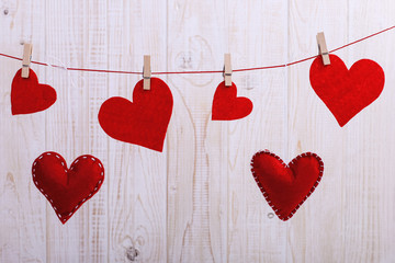 Red hearts made of handmade felt hanging on a rope with a pin, Concept, banner, save space.