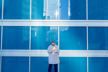 Portrait of a young business woman standing with a laptop in the city center