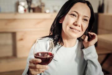 Pleasant woman holding a glass of wine