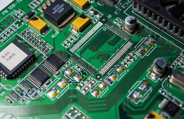 The green motherboard from the personal computer. Modern electronics and details. Correction of malfunctions. Texture, background.