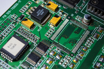 The green motherboard from the personal computer. Modern electronics and details. Correction of malfunctions. Texture, background.