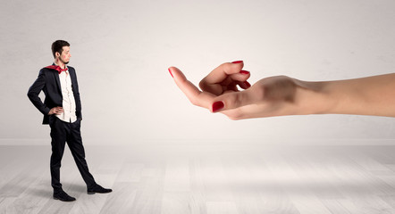 Businessman with kisses on his face in an empty space where a big hand baiting him
