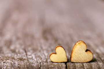 Two wooden hearts placed nicely on a vintage wood background. Copy space, love concept.