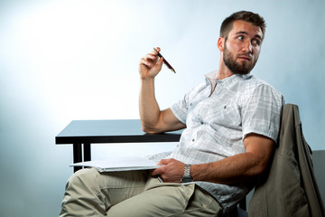 Portrait eines jungen Mannes mit Notizblock und Kugelschreiber in der Hand