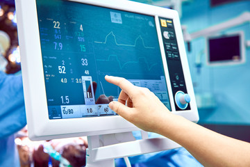 Monitoring patient's vital sign in operating room. doctor cheking at patient's vital signs. Cardiogram monitor during surgery in operation room. - obrazy, fototapety, plakaty